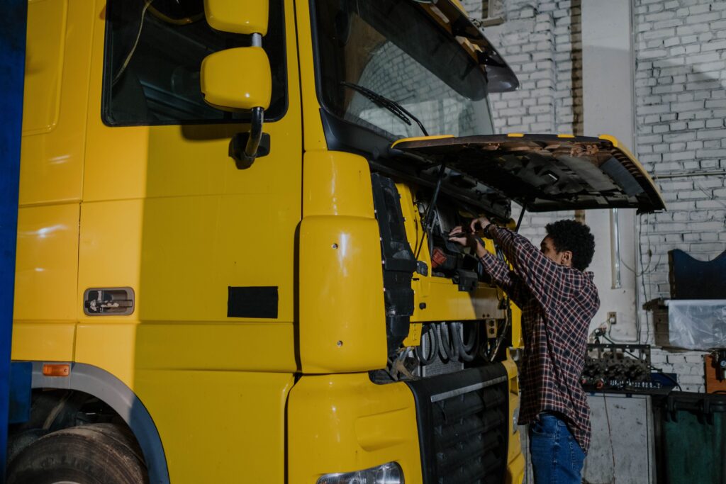 truck mechanic jobs in Canada - mechanic working on a yellow truck engine in a workshop
